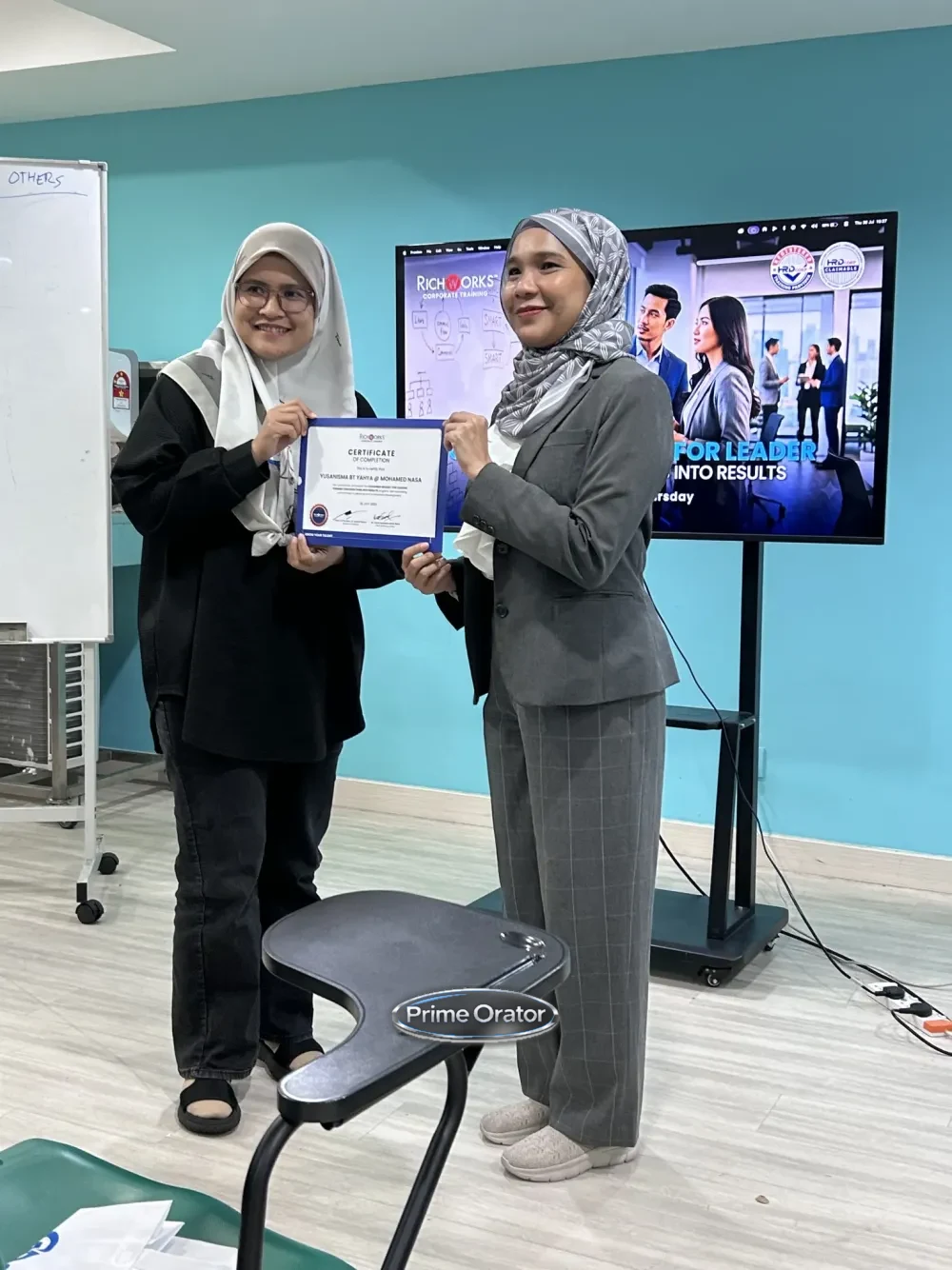 Trainer presenting a certificate of completion to a participant after a Coaching Mindset for Leaders session